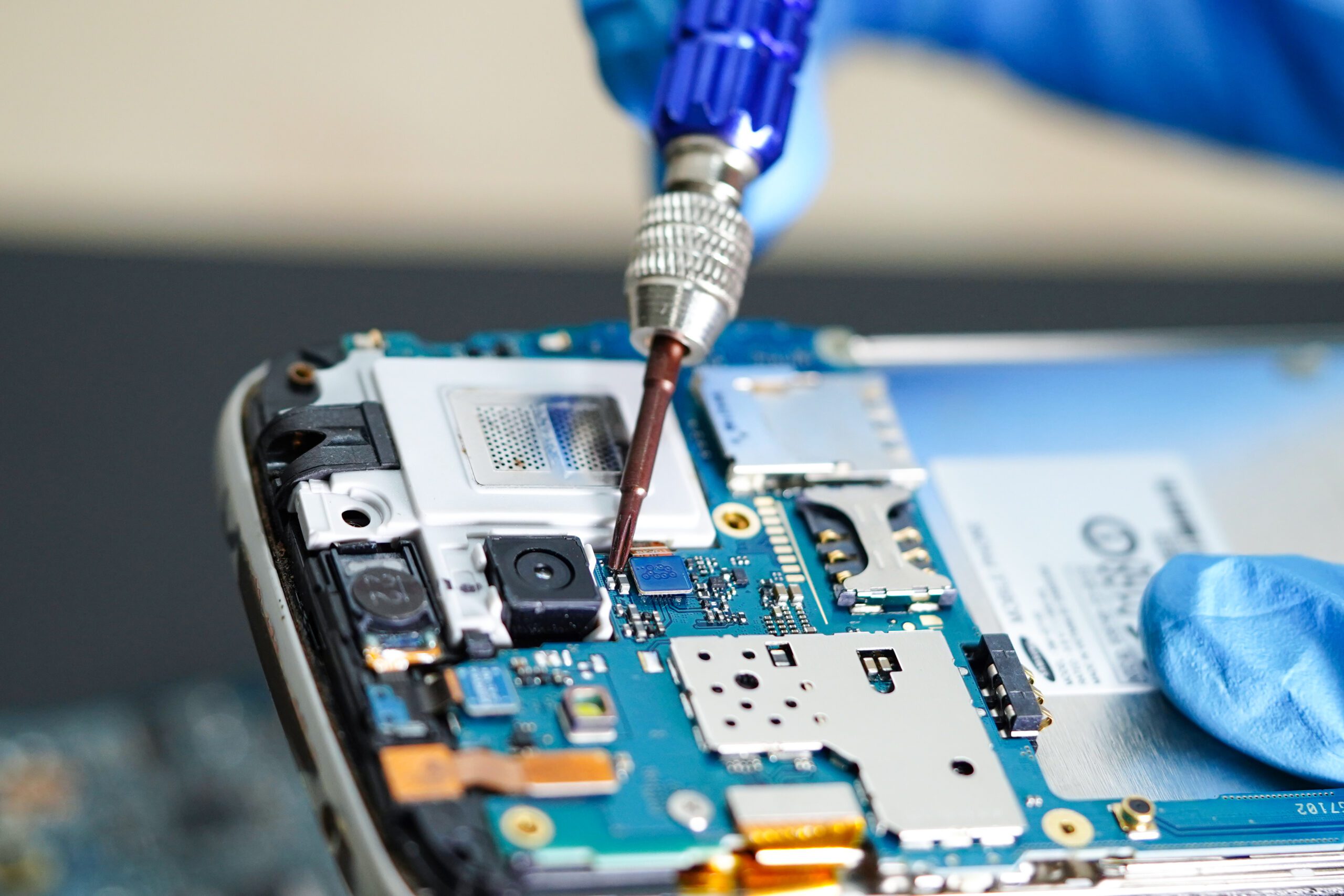 Technician working on a phone main board during a repair