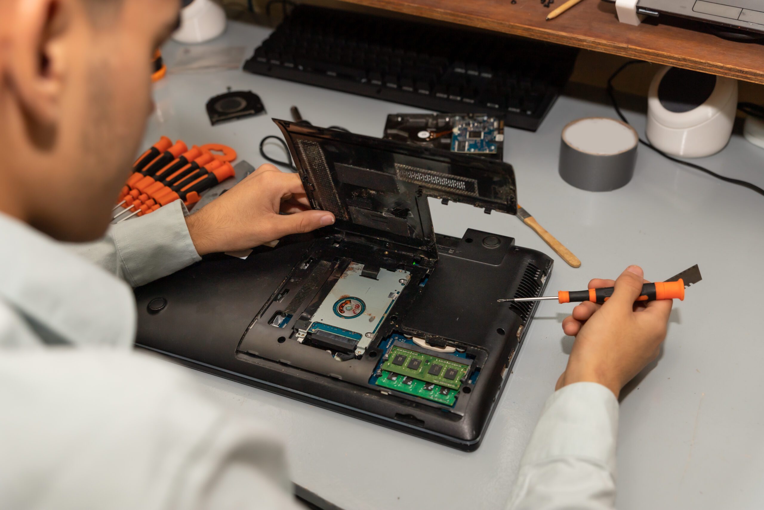 A computer repair technician repairing a laptop